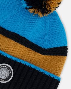 Our Knit Hat Blue, Black and Spice is a must-have on cold weather days. Oh-so-soft in acrylic yarn, this beanie hat features an easy pull-on fit with a cozy lining, a fluffy pompom on top, and a horizontal stripe pattern that makes it easy to mix and match with a variety of different coats and snowsuits. Beanie hat Pompom Logo patch 100% Acrylic - Lining: 94% Polyester, 6% Elastane Fits true to size From 2 years to 14 years Blue Knit Beanie For Winter, Blue Knit Beanie Cap, Blue Acrylic Yarn Winter Hat, Blue Winter Beanie Cap, Blue Winter Beanie For Outdoor Use, Blue Winter Beanie For Outdoor, Blue Knit Beanie One Size, Blue Knit Beanie Hat, Blue Knit Beanie (one Size Fits Most)