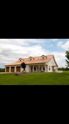 a large white house sitting on top of a lush green field