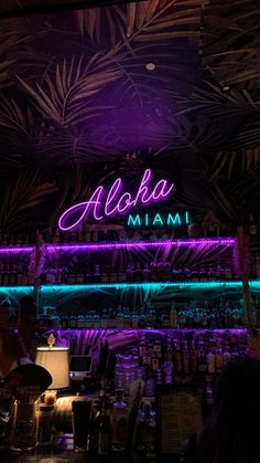 the neon sign above the bar says aloha in front of purple and green lights