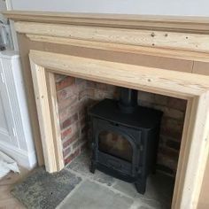 a wood burning stove sitting inside of a brick fireplace