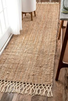 a rug with tassels on the floor in a living room