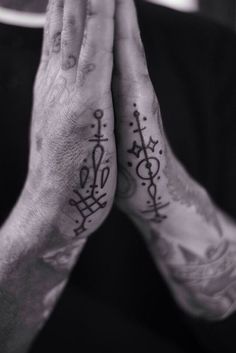 two hands that have tattoos on them and one has the word love written in it