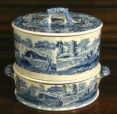 two blue and white containers sitting on top of a wooden table