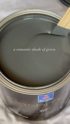 a can of green paint with a wooden spoon in it