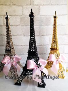 three miniature eiffel tower models with pink bows