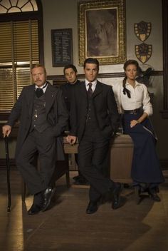 a group of people standing next to each other in front of a wooden table and chair