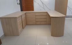 an empty kitchen with wooden cabinets and marble flooring