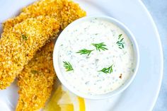 a plate with some fried fish sticks on it and a bowl of ranch dressing next to it