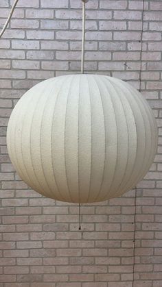 a white lamp hanging from a brick wall