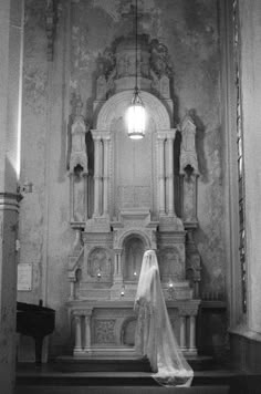 a woman in a wedding dress standing at the alter