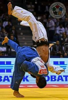 a man doing a handstand on the ground in front of an audience at a competition