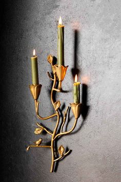 a wall mounted candle holder with three candles