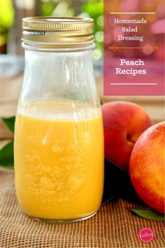 a glass jar filled with liquid next to two peaches