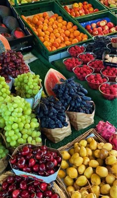 many different types of fruit are on display at the market together, including plums, watermelon, apples and oranges