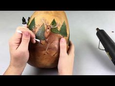 someone is painting an egg with deer on it