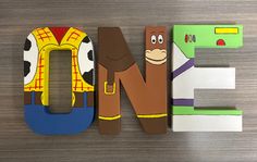 the letter e is made up of wooden letters with cartoon characters on them, including a cow and a man