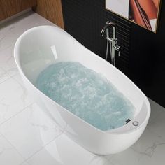 a bathtub filled with water sitting on top of a white tiled floor