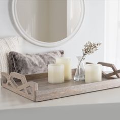 three candles on a tray with a mirror in the background