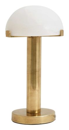 a brass table lamp with a white glass shade on it's top and base