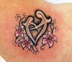 a tattoo on the back of a woman's shoulder with pink flowers and hearts