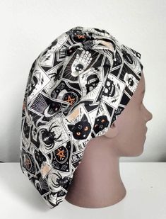 a head wearing a black and white scrub hat with skulls, cats and bones on it