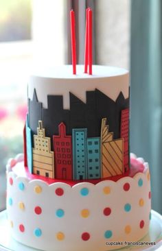 a three tiered cake decorated with buildings and polka dots