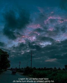 the sky is dark and cloudy at night with clouds in the foreground, some cars driving down the road