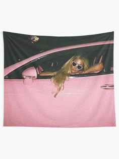 a woman wearing sunglasses sitting in a pink car