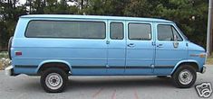 an old blue van parked in a parking lot