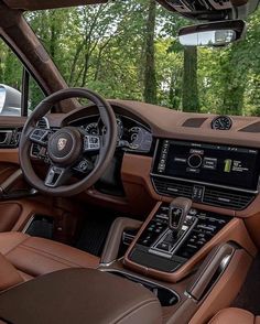 the interior of a luxury car with brown leather seats and dashboard, steering wheel and dash board