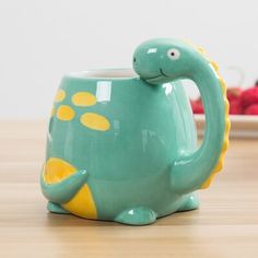 a teapot shaped like a turtle on a table with strawberries in the background