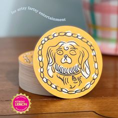 a yellow coaster with a drawing of a dog on it's face and chain around its neck