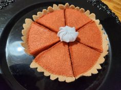 an orange pie sitting on top of a black plate