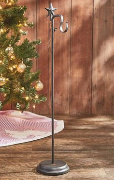 a christmas tree in the corner of a room with a star decoration on it's pole