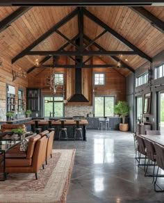 a large open concept living room and dining area with wood paneling on the ceiling