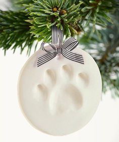 an ornament shaped like a paw print hanging from a christmas tree