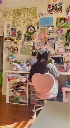 a person sitting at a desk with many pictures on the wall