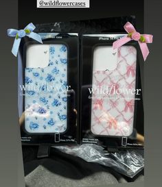 two cell phones are in the packaging with bows on their head and one has a pink bow