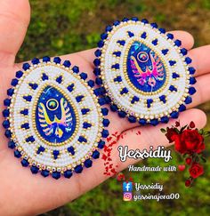 two handmade earrings with blue and white designs on the front, one is decorated with beads