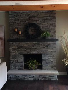 a living room with a stone fireplace and potted plants