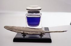 a pen and ink bottle sitting on top of a table