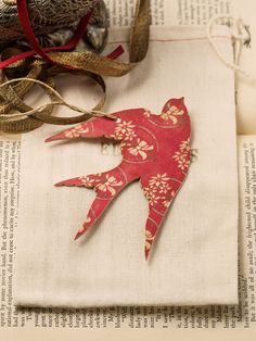 an ornament is sitting on top of a piece of paper next to some ribbon