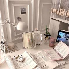 an open book sitting on top of a desk next to a laptop computer and other items