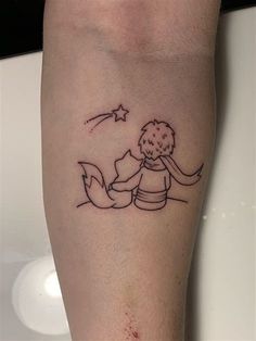 a small tattoo on the leg of a person with a star above her head and an arrow