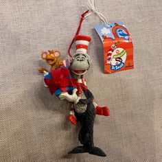 a cat in the hat ornament hanging on a wall next to a bag