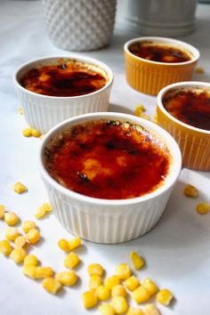 three bowls filled with food sitting on top of a white table covered in corn kernels