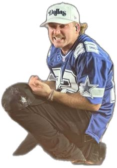 a man sitting on the ground wearing a hat