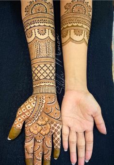 two hands with henna tattoos on them