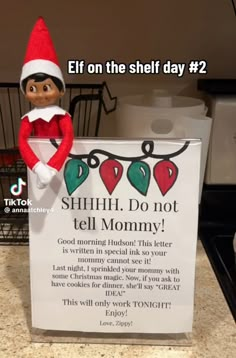 an elf is holding a sign that says, elf on the shelf day 2