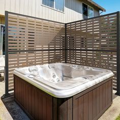 a hot tub sitting in the middle of a yard next to a fence and building